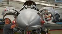 Mekanik pesawat terbang melakukan perbaikan pesawat F-16 Falcon di pangkalan Angkatan Udara Hill di Ogden, Utah (20/12). Di pangkalan udara ini jet temput A-10 dan F-16 dilakukan perbaikan dan diperiksa kesiapannya. (George Frey/Getty Images/AFP)
