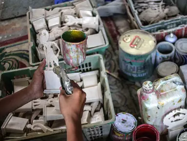 Pekerja mengecat plakat yang sedang dibuat di Industri Rumahan Pluit, Penjaringan, Jakarta Utara, Rabu (30/10/2019). Plakat yang terbuat dari bahan baku resin plastik tersebut dijual dengan harga Rp 50.000 hingga Rp 100.000. (Liputan6.com/Faizal Fanani)