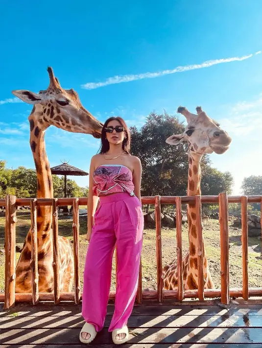 Di sini, Jessica Iskandar tampil mengenakan crop top bernuansa merah muda keunguan bermotif abstrak dengan detail pita di bagian depan, dipadu dengan celana panjang bernuansa senada. Foto: Instagram.