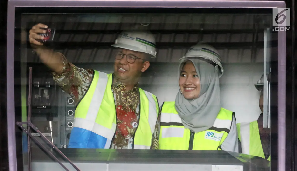 Gubernur DKI Jakarta Anies Baswedan berswafoto di dalam kereta MRT di Depo Lebak Bulus, Jakarta, Kamis (12/4). Anies menyebut sudah ada 35 dari 65 masinis yang akan mengoperasikan kereta MRT tersebut. (Liputan6.com/Arya Manggala)