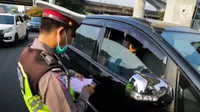 Polisi menilang kendaraan saat pemberlakuan perluasan sistem ganjil genap di kawasan Jalan Fatmawati Raya, Jakarta, Senin (9/9/2019). Pada masa uji coba, polisi hanya melakukan upaya preventif seperti sosialisasi kepada pelanggar. (Liputan6.com/Faizal Fanani)