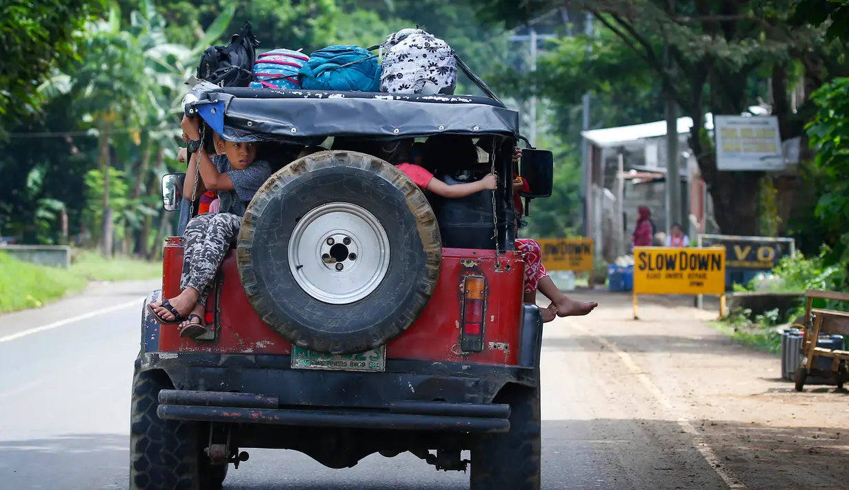 Sebuah keluarga mengungsi dari kota Marawi menuju pusat pengungsian di kota Bal-oi, Filipina selatan (26/5). Akibat adanya bentrokan antara kelompok militan Islam dan tentara pemerintah warga mengungsi ketempat aman.  (AP Photo / Bullit Marquez)