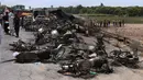 Sejumlah bangkai kendaraan yang hangus terbakar akibat ledakan truk tangki minyak yang terbalik dan meledak di jalan raya dekat Bahawalpur, Pakistan (25/6). Dikabarkan, sedikitnya 123 orang tewas dan 100 lainnya mengalami luka-luka. (AP Photo / Iram Asim)