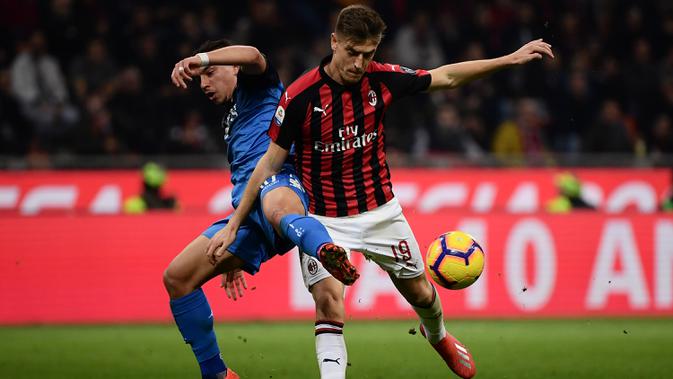 Striker AC Milan, Krzysztof Piatek, berebut bola dengan bek Empoli, Ismael Bennacer, pada laga Serie A di Stadion San Siro, Milan, Jumat (22/2). Milan menang 3-0 atas Empoli. (AFP/Marco Bertorello)