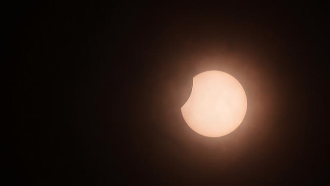 Bulan sebagian menutupi matahari selama gerhana matahari cincin (Annular Solar Eclipse) yang terlihat dari Kolombo, Sri Lanka, Minggu (21/6/2020). Sebagian penduduk Bumi bisa menyaksikan fenomena langka, Gerhana Matahari Cincin. (Photo by LAKRUWAN WANNIARACHCHI / AFP)