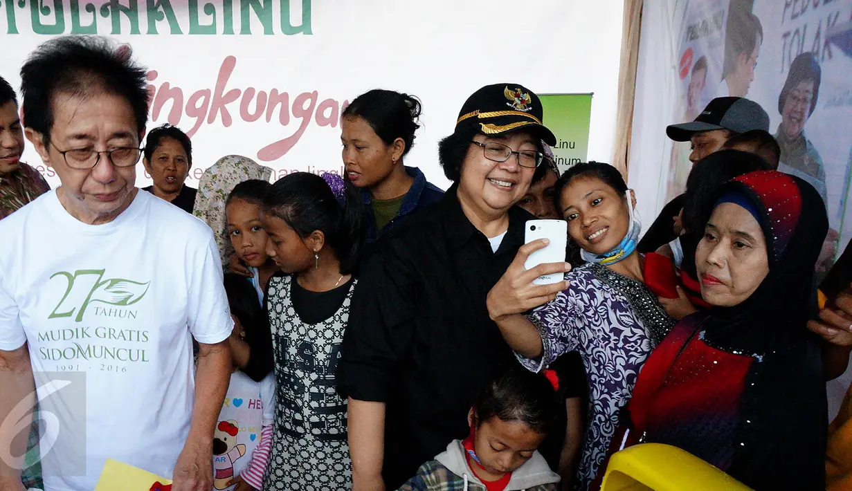 Menteri LHK, Siti Nurbaya (baju hitam) berfoto bersama pedagang jamu sebelum  pelepasan mudik gratis Sido Muncul di kawasan TMII, Jakarta, Jumat (7/1). Mudik gratis yang ke-27 ini memberangkatkan sebanyak 16 ribu pedagang jamu. (Liputan6.com/Fery Pradolo)