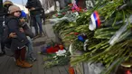Warga Moskow melihat karangan bunga di luar Kedutaan Besar Prancis di Moskow, Sabtu (14/11/2015) . Karangan bunga tersebut untuk menghormati para korban serangan mematikan di Paris. (AFP Photo/Dmitry Serebryakovi)