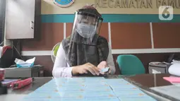 Petugas Dinas Kependudukan dan Catatan Sipil menggunakan pelindung wajah saat mengurus KTP-el di Kecamatan Pamulang, Tangerang Selatan, Rabu (3/6/2020). Sejumlah kantor pelayanan pemerintah melaksanakan protokol kesehatan yang ketat untuk memutus rantai penyebaran covid-19. (merdeka.com/Arie Basuki)