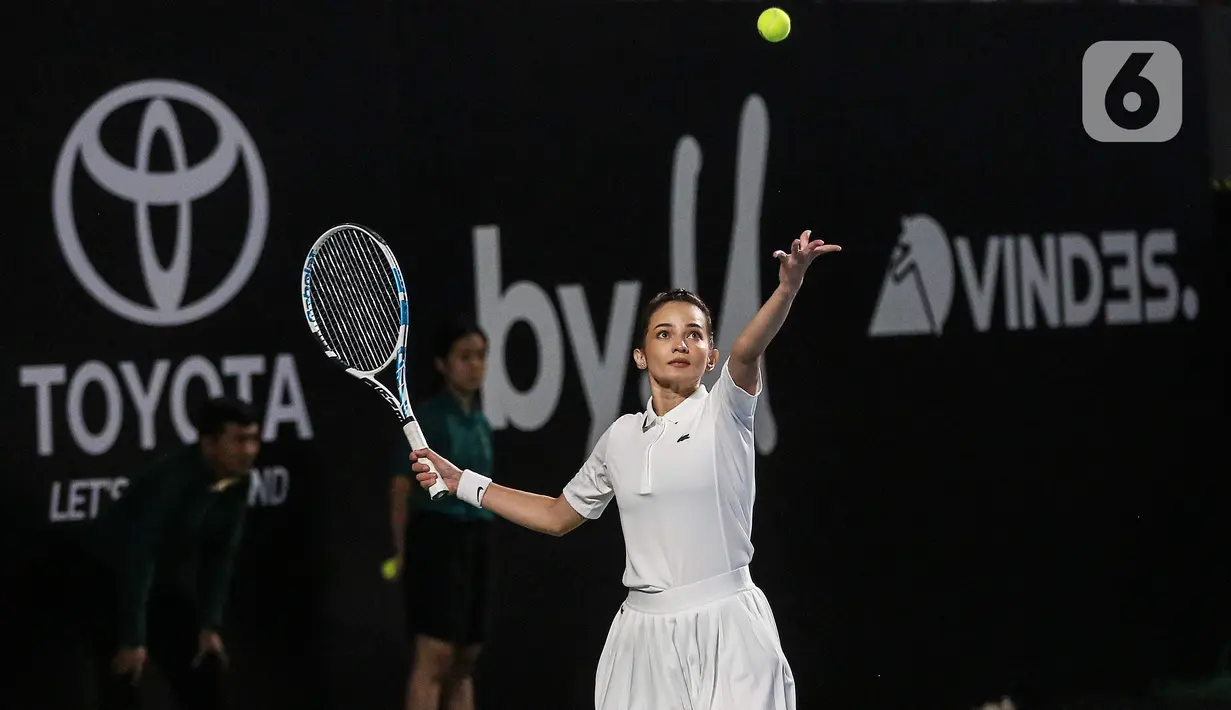 Enzy Storia melakukan servis saat melawan Gading Marten/Wulan Guritno pada pertandingan pembuka Tiba Tiba Tenis di Tennis Indoor Senayan, Jakarta, Sabtu (12/11/2022). Pasangan Dion Wiyoko/Enzy Storia berhasil mengalahkan Gading Marten/Wulan Guritno dua set langsung dengan skor meyakinkan, 6-2 dan 6-3. (Liputan6.com/Johan Tallo)
