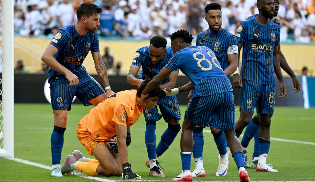 Kiper Al Hilal, Yassine Bounou (tengah) melakukan selebrasi dengan rekan setimnya setelah menggagalkan tendangan penalti pemain Real Madrid, Federico Valverde dalam laga Grup H Piala Dunia Antarklub 2025 melawan Real Madrid di Hard Rock stadium, Miami, Amerika Serikat, Kamis (19/06/2025) WIB. (AFP/Patricia De Melo Moreira)