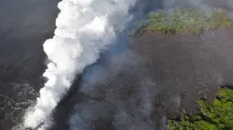 Pemandangan saat lava pijar Gunung Kilauea mengalir ke laut di dua lokasi dekat Pahoa, Hawaii, Amerika Serikat, Minggu (20/5). (Survei Geologi AS via AP)