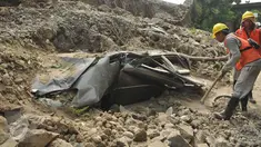  Warga dibantu petugas mengevakuasi sebuah mobil minibus di permukiman RT 08/10, Duri Pulo, Jakarta,  Senin (13/6). Tembok setinggi empat meter roboh menimpa sebuh mobil mini bus di bawahnya. (Liputan6.com/Gempur M Surya)