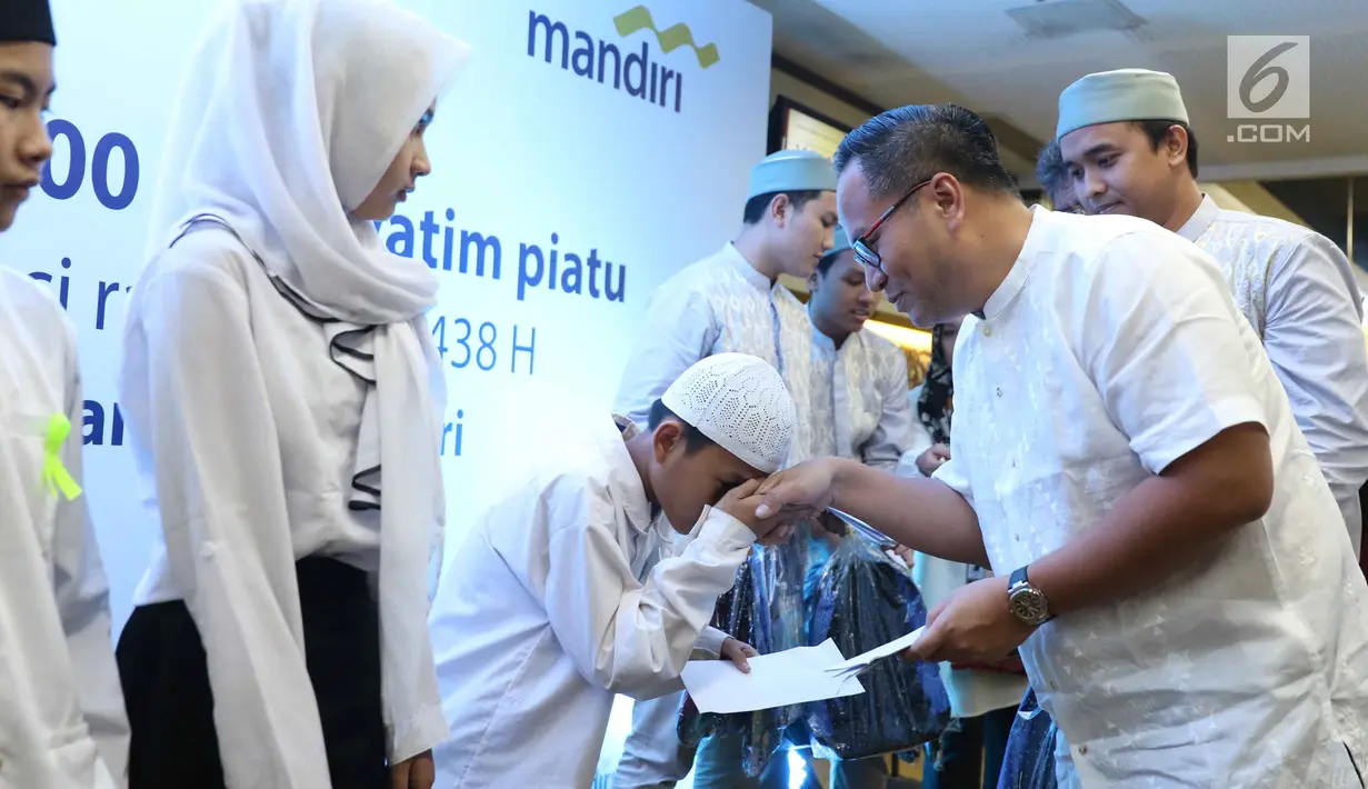 Seorang anak menyalami Dirut Bank Mandiri Kartika Wirjoatmodjo saat acara buka puasa di Jakarta, Minggu (11/6).  Dalam kegiatan ini Bank Mandiri Group memberikan bingkisan Ramadan kepada 21.000 anak yatim piatu. (Liputan6.com/Angga Yuniar)