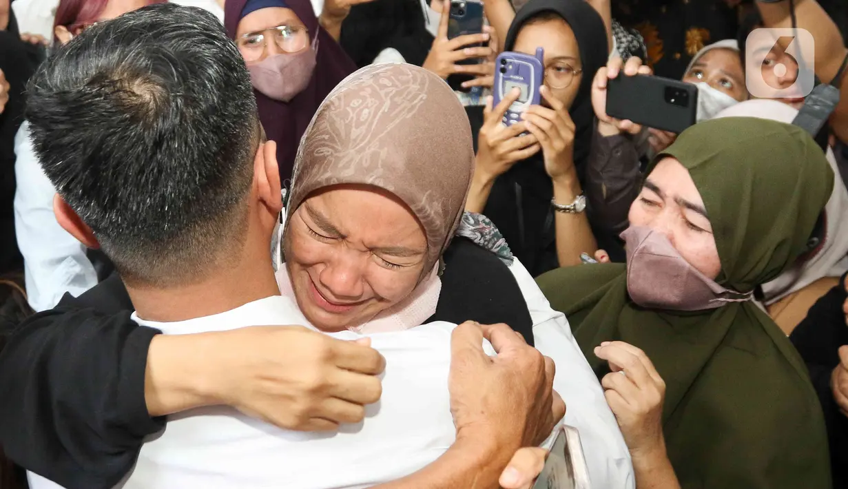 Terdakwa kasus dugaan perintangan penyidikan pada kasus pembunuhan Brigadir Yosua, Irfan Widyanto memeluk sang istri usai menjalani sidang putusan di Pengadilan Negeri Jakarta Selatan, Jumat (24/2/2023). Vonis ini lebih ringan dari tuntutan jaksa penuntut umum (JPU) terhadap peraih Adhi Makayasa itu. Sebelumnya, JPU menuntut hukuman selama satu tahun penjara. (Liputan6.com/Herman Zakharia)