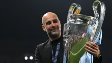 Selebrasi pelatih Manchester City, Pep Guardiola dengan trofi Liga Champions 2022/2023 setelah mengalahkan Inter Milan 1-0 pada laga final di Ataturk Olympic Stadium, Istanbul (10/6/2023). (AFP/Paul Ellis)