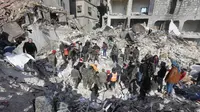 Tim penyelamat Suriah mencari korban dan penyintas yang terjebak di bawah reruntuhan bangunan yang runtuh di Aleppo, Selasa 7 Februari 2023, setelah gempa bumi mematikan yang melanda wilayah tersebut pada hari sebelumnya. Gempa berkekuatan 7,8 SR tersebut terjadi di dekat kota Gaziantep, Turki, menewaskan lebih dari 2.300 orang di Turki dan lebih dari 1.400 orang di negara tetangganya, Suriah. (LOUAI BESHARA/AFP)