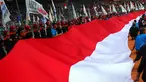 Di antara keriuhan teriakan buruh yang meneriakkan beragam tuntutan, sebuah bendera berukuran 100 meter persegi dibentangkan (Liputan6.com/Miftahul Hayat) 