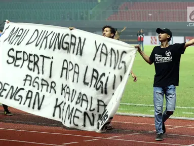 Suporter tim Maung Bandung membentangkan spanduk usai menyaksikan laga Bhayangkara FC melawan Persib di Stadion Patriot Candrabhaga, Bekasi, Minggu (4/6). Persib kalah 0-2 dari Bhayangkara FC. (Liputan6.com/Helmi Fithriansyah)