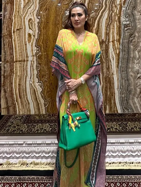 Liza Natalia mengenakan kaftan warna cerah dengan motif tribal. Kaftan model kerah v neck dipadukan dengan Hermes hijaunya. [(@lizanataliaofficial]