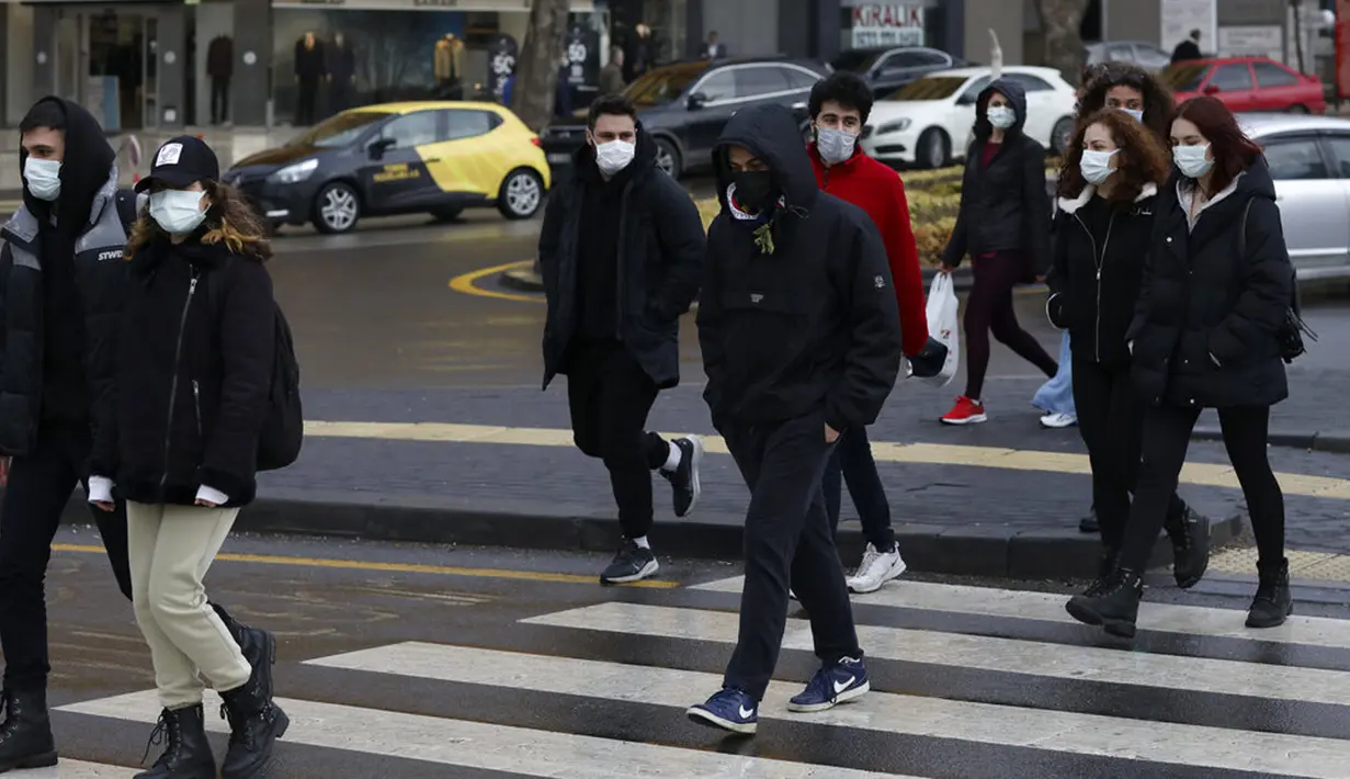 Orang-orang yang memakai masker untuk membantu melindungi dari penyebaran COVID-19 berjalan di Ankara, Turki, Senin (29/3/2021). Turki kembali memberlakukan lockdown akhir pekan dan pembatasan selama Ramadan menyusul peningkatan tajam kasus COVID-19. (AP Photo/Burhan Ozbilici)