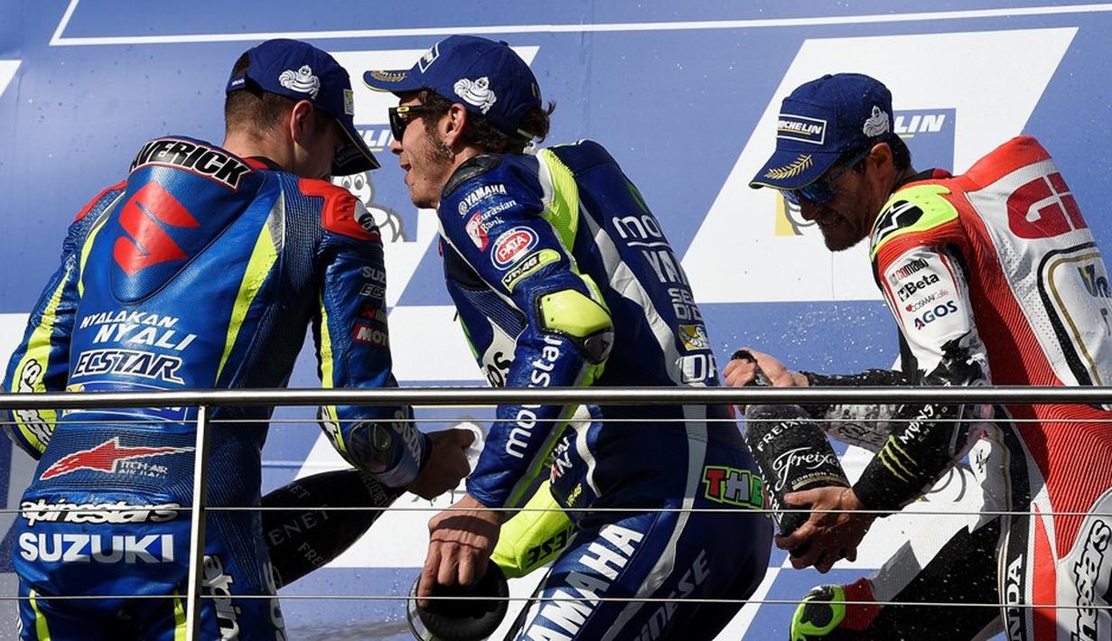 Valentino Rossi merayakan kemenangan bersama sang juara MotoGP Australia, Cal Crutchlow (kanan), dan peringkat ketiga, Maverick Vinales, di podium Sirkuit Phillip Island, Minggu (23/10/2016). (AFP/Saeed Khan)