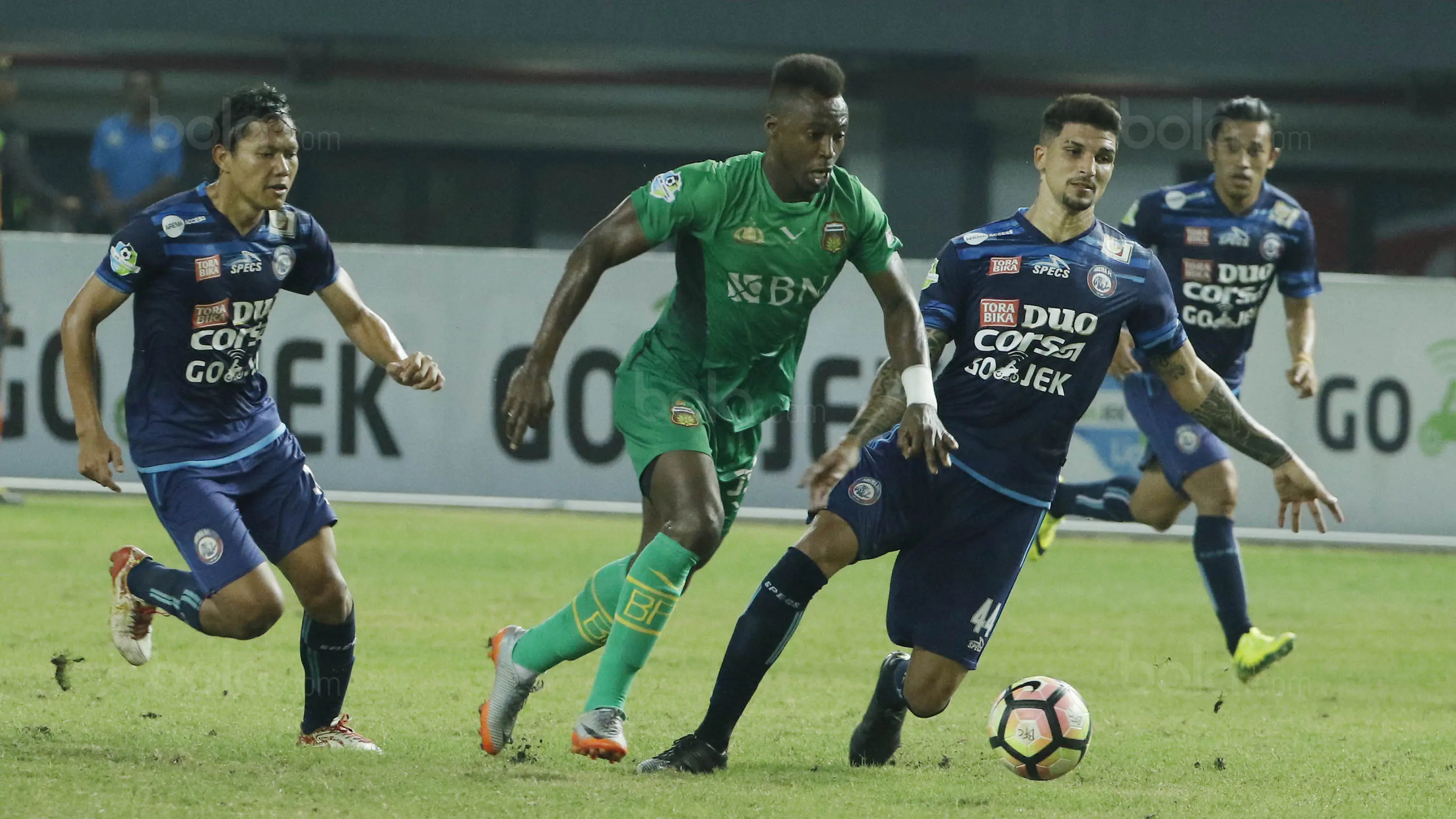 Bek Arema FC, Arthur Cunha, berusaha menghadang striker Bhayangkara FC, Guy Junior, pada laga Liga 1 di Stadion Patriot, Bekasi, Jumat (4/8/2017). Bhayangkara FC menang 2-1 atas Arema FC. (Bola.com/M Iqbal Ichsan)