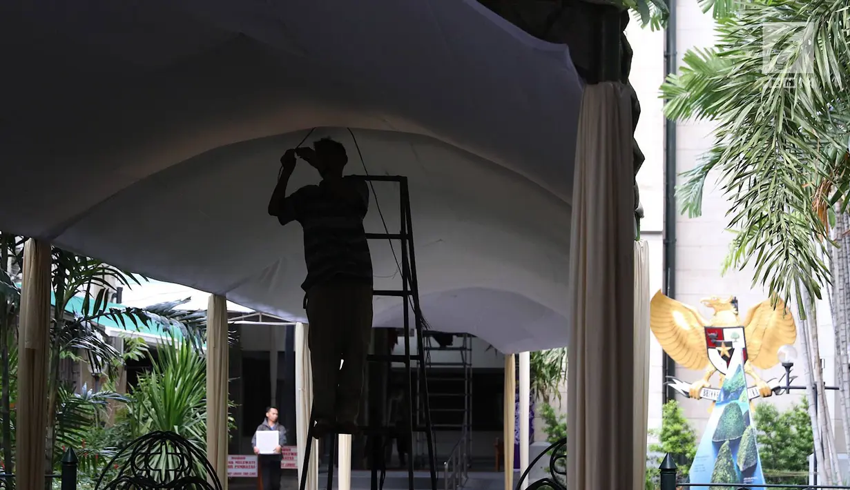 Pekerja menyelesaikan pembuatan tenda dan dekorasi Natal di Gereja Katedral, Jakarta, Kamis (20/12). Gereja Katedral menyambut perayaan Misa Natal dengan mendirikan tenda. (Liputan6.com/Immanuel Antonius)