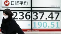 Seorang wanita berjalan melewati layar monitor yang menunjukkan indeks bursa saham Nikkei 225 Jepang dan lainnya di sebuah perusahaan sekuritas di Tokyo, Senin (10/2/2020). Pasar saham Asia turun pada Senin setelah China melaporkan kenaikan dalam kasus wabah virus corona. (AP Photo/Eugene Hoshiko)