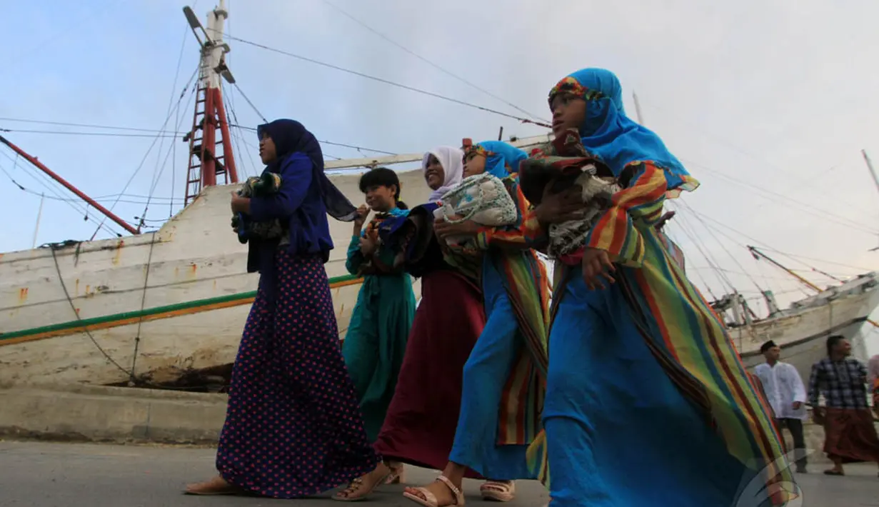 Sejumlah warga berjalan untuk melaksanakan salat Idul Fitri 1435 H di Pelabuhan Sunda Kelapa, Jakarta, Senin (28/7/14). (Liputan6.com/Miftahul Hayat)