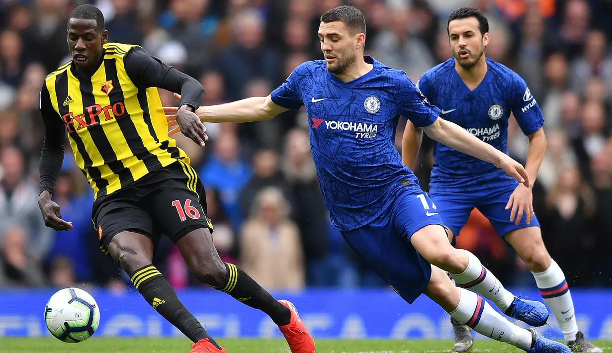 Gelandang Watford, Abdoulaye Doucoure, berusaha melewati gelandang Chelsea, Mateo Kovacic, pada laga Premier League di Stadion Stamford Bridge, London, Minggu (5/5). Chelsea menang 3-0 atas Watford. (AFP/Ben Stansall)