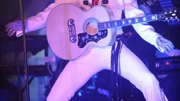 Penampilan peniru gaya Elvis Presley, Pete Storm dari Inggris saat Festival Elvis Skotlandia yang digelar pertama kali di Grangemouth, 8 April 2016. Acara ini memikat penonton yang ingin menyaksikan aksi kontestan mirip Elvis Presley. (Andy Buchanan/AFP)
