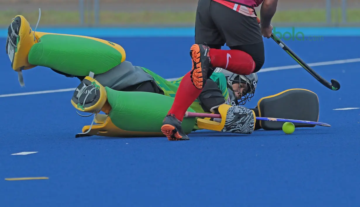 Penjaga gawang Timnas Hoki Putri Indonesia berusaha menghalau bola dari tembakan rekannya saat latihan di Lapangan Hoki, Senayan, Jakarta, Selasa (2/4/2018). Tim Hoki terus melakukan adaptasi lapangan jelang Asian Games 2018. (Bola.com/Nick Hanoatubun)