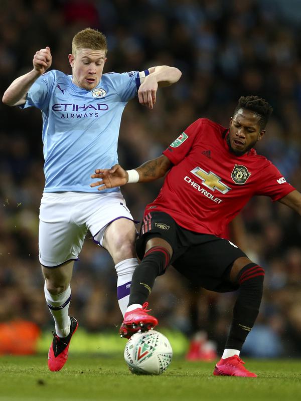 Gelandang Manchester City, Kevin De Bruyne berebut bola dengan gelandang Manchester United, Fred pada pertandingan semifinal Piala Liga Inggris di stadion Etihad, Manchester, Rabu (29/1/2020). MU menang 1-0 atas City namun gagal ke final karena skor agregat 3-2. (AP Photo/Dave Thompson)