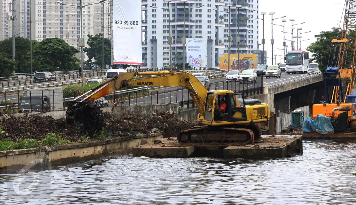 Pekerja dibantu alat berat menyelesaikan pembangunan turap di sepanjang Kali Grogol, Jakarta, Senin (21/11). Pembangunan turap dilakukan untuk mencegah meluapnya air kali saat hujan dan ditargetkan selesai 20 Desember 2016. (Liputan6.com/Gempur M Surya)