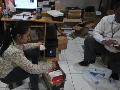 Petugas Bareskrim Polri melakukan penggeledahan dan penyitaan terhadap sejumlah telepon seluler ilegal di gudang distributor, di ruko kawasan Cempaka Mas, Jakarta, Senin(15/6/2015). (Liputan6.com/Herman Zakharia)