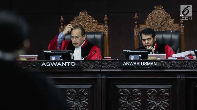 Ekspresi Ketua Majelis Hakim Mahkamah Konstitusi Anwar Usman (kanan) saat memimpin sidang sengketa Pilpres 2019 di Gedung MK, Jakarta, Selasa (18/6/2019). Sidang tersebut beragendakan mendengarkan jawaban dari termohon. (Liputan6.com/Faizal Fanani)