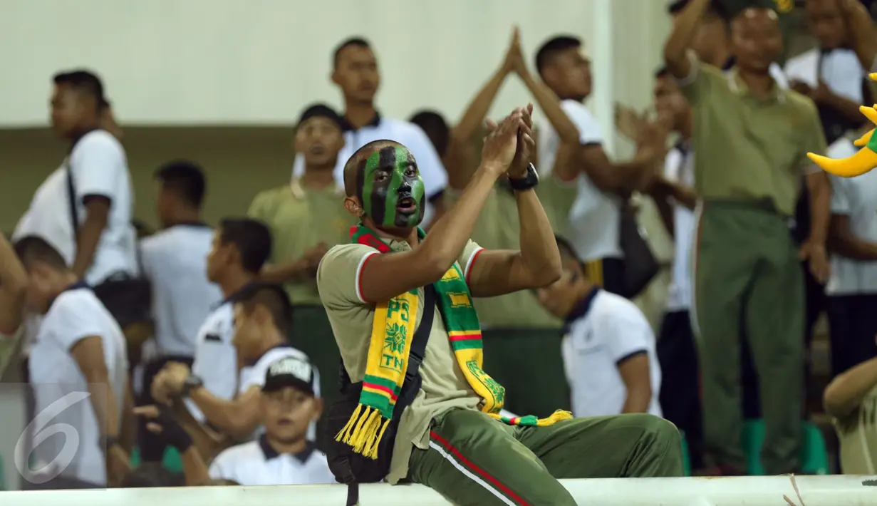 Salah satu suporter PS TNI membentangkan tangan usai menyaksikan laga timnya melawan Persib di lanjutan Liga 1 di Stadion Pakansari, Kab Bogor, Sabtu (22/4). Laga PS TNI melawan Persib berakhir imbang 2-2. (Liputan6.com/Helmi Fithriansyah)