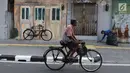 Pengendara sepeda melintas di depan Kampung Tematik Sketsa di kawasan Penjaringan, Jakarta Utara, Rabu (1/7). Sketsa-sketsa yang menghiasi kawasan tersebut dibuat dalam rangka menyambut Asian Games XVIII Tahun 2018. (Liputan6.com/Immanuel Antonius)