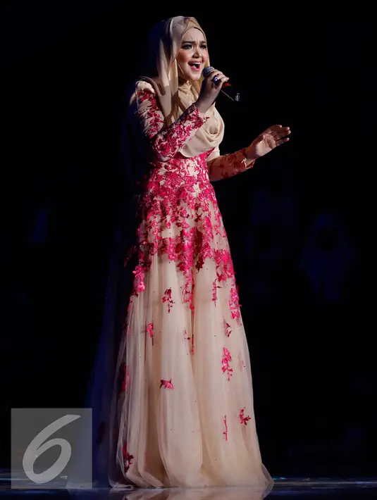 Penampilan Siti Nurhaliza saat membawakan lagu saat Konser Raya 21 Tahun Indosiar, Istora Senayan, Jakarta (11/1/2016). Tampil sederhana mengenakan busana hijab berwarna cokelat bertabur kembang berwarna merah. (Liputan6.com/Gempur M Surya)