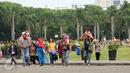 Rombongan warga berjalan-jalan di kawasan Monumen Nasional, Jakarta, Minggu (25/12). Libur perayaan Natal 2016 dimanfaatkan sejumlah warga untuk berwisata di kawasan Monumen Nasional. (Liputan6.com/Helmi Fithriansyah)