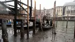 Penumpang turun dari gondola yang berlabuh di sepanjang kanal saat air surut di Venesia, Italia, 21 Februari 2023. Beberapa kanal sekunder Venesia praktis mengering akhir-akhir ini akibat gelombang surut terkait dengan sistem cuaca bertekanan tinggi yang berkepanjangan. (AP Photo/Luigi Costantini)