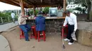 Seorang pria sedang merokok ketika Miguel Andagana mengambil puntung rokok di wilayah Puerto Ayora, Kepulauan Galapagos (9/10). Andagana ingin diakui oleh Guinness Records sebagai orang yang memberantas puntung rokok. (REUTERS/Guillermo Granja)