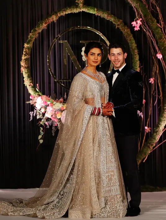 Aktris Bollywood Priyanka Chopra dan musisi AS Nick Jonas berpose saat resepsi pernikahan mereka di New Delhi, India, Selasa (4/12). Upacara pernikahan kedua mereka digelar secara Hindu pada 2 Desember 2018. (AP Photo/Altaf Qadri)
