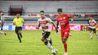 Pemain Persija Jakarta Dony Tri Pamungkas dikawal ketat pemain belakang Madura United Dodi Alekvan Djin dalam pekan ke-32 BRI Liga 1 2021/2022 di Stadion Kapten I Wayan Dipta, Kamis (17/3/2022). (Bola.com/Maheswara Putra)