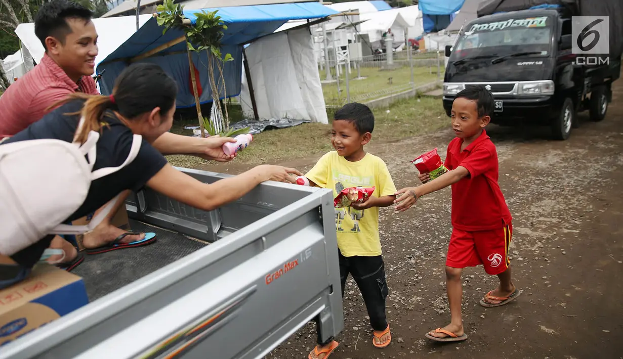 Anak-anak menerima susu kemasan dari relawan di sekitar tenda Posko Pengungsi Rendang, Bali, Sabtu (2/12). (Liputan6.com/Immanuel Antonius)