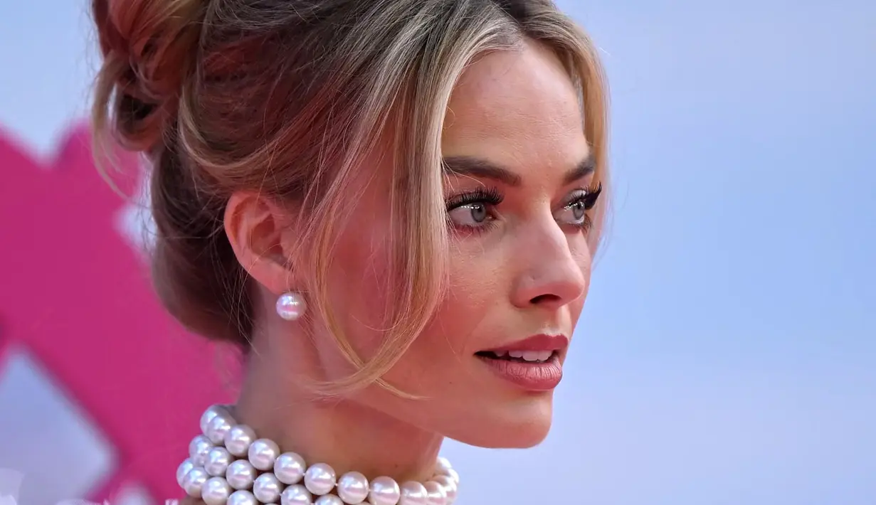 Margot melengkapi tampilan vintage dengan sepasang sarung tangan sutra panjang dan kalung mutiara berlapis. (AFP/Justin Tallis)