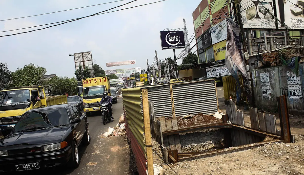 Sejumlah pengendara melintas di depan proyek galian sedalam 12 meter di Jalan Alternatif Cibubur, Jakarta, Senin (10/11/2014). (Liputan6.com/Faizal Fanani) 