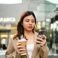 ilustrasi perempuan bekerja pegang ponsel/Makhh/Shutterstock