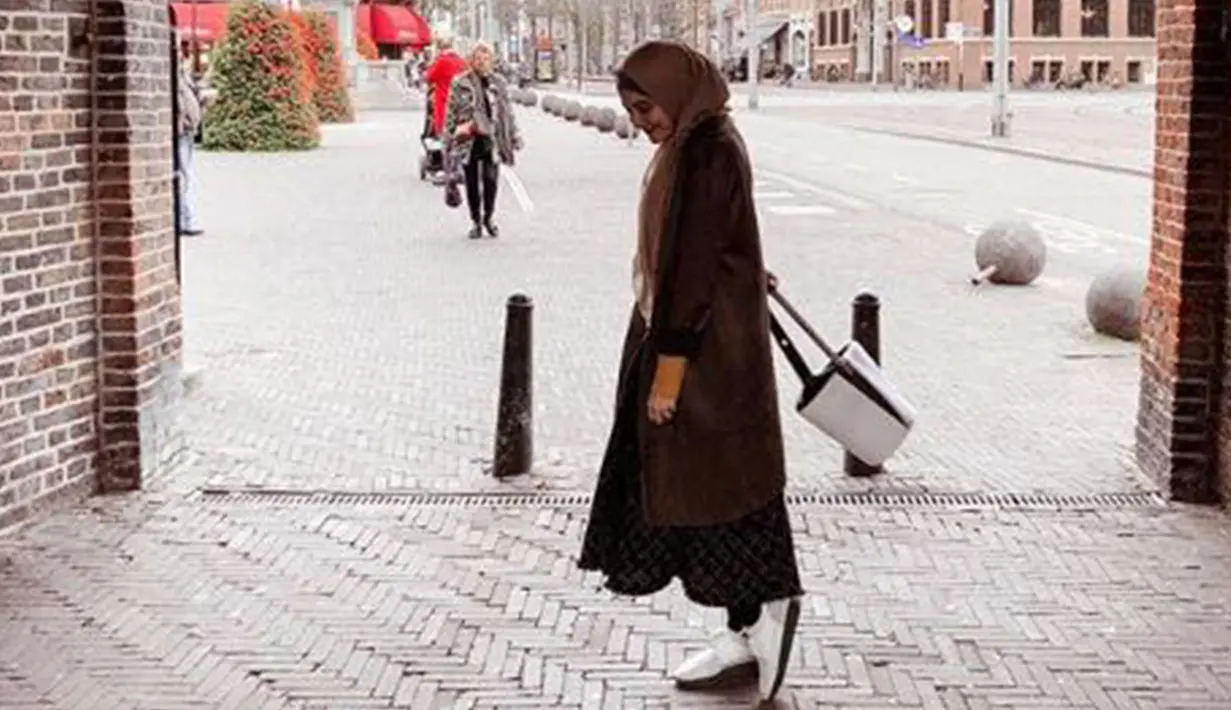Berlibur ke luar negeri, Kia menggunakan coat berwarna coklat yang padukan dengan tas dan sepatu berwarna putih. (Liputan6.com/IG/@zaskiasungkar)