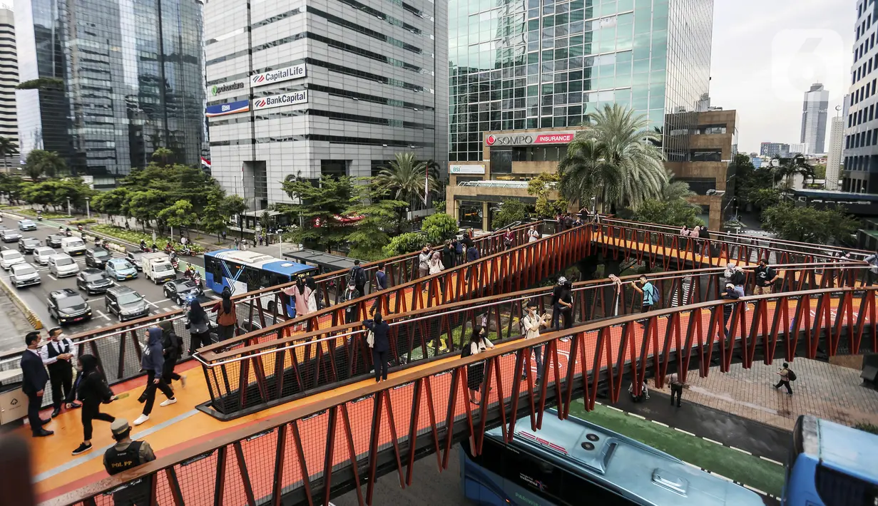 Warga melintasi Jembatan Penyeberangan Orang (JPO) Pinisi di Jalan Jenderal Sudirman, Karet, Jakarta, Selasa (15/3/2022). Keberadaan JPO Pinisi langsung disambut baik oleh warga dengan ramai-ramai berkunjung untuk sekadar melakukan swafoto. (Liputan6.com/Johan Tallo)